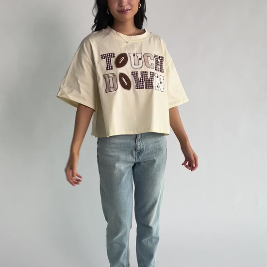 Jason Graphic Tee in Cream with vintage football graphic, gingham, lace and bow appliqué, crew neckline, and short sleeves.