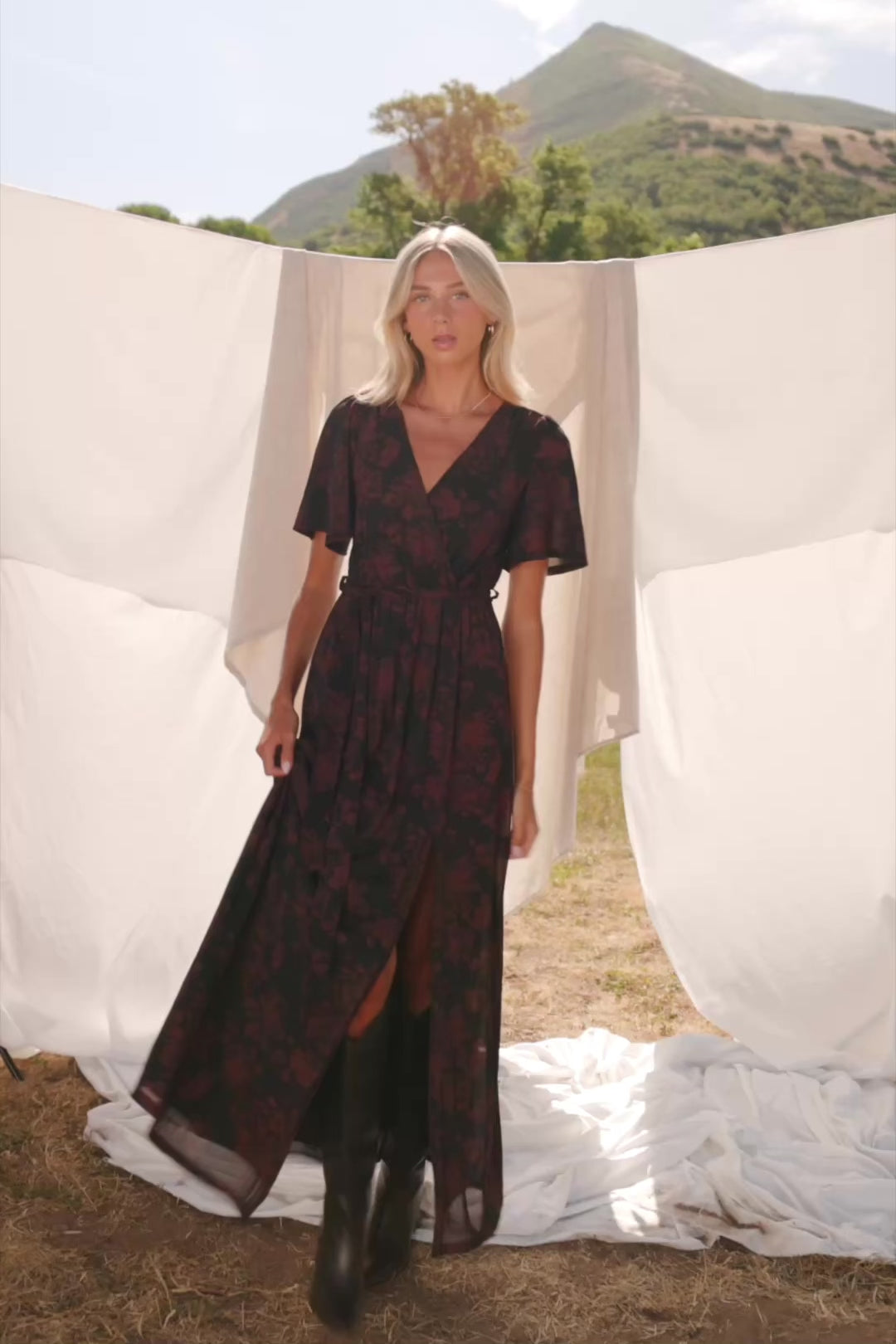 Reverie Maxi Dress in Black + Burgundy with floral print, surplice V-neck, sash waist, long sleeves, and side leg slit.