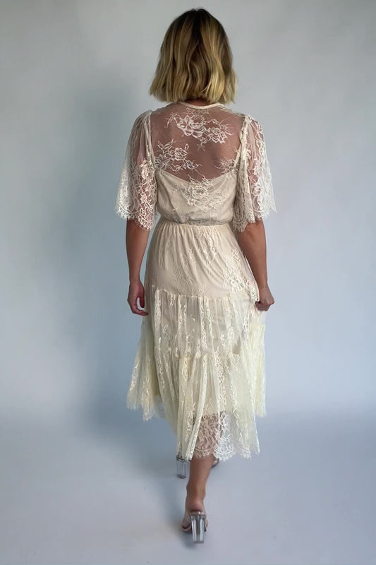 Brittany Lace Midi Dress in Vintage Cream with deep V-neck, sheer lace sleeves, elastic waist, and tiered skirt.