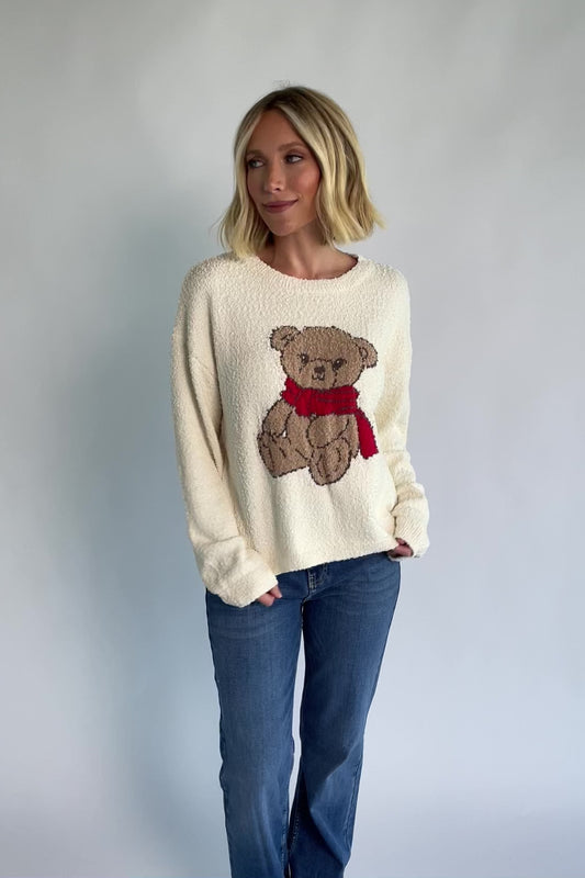 Junie Cozy Bear Sweater in Ivory with teddy bear graphic, red scarf, crew neckline, and ribbed trim.