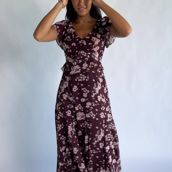 Teuila Midi Dress in Dark Clove + Blush Floral with V-neckline, ruched bust, flutter sleeves, and ruffle skirt.