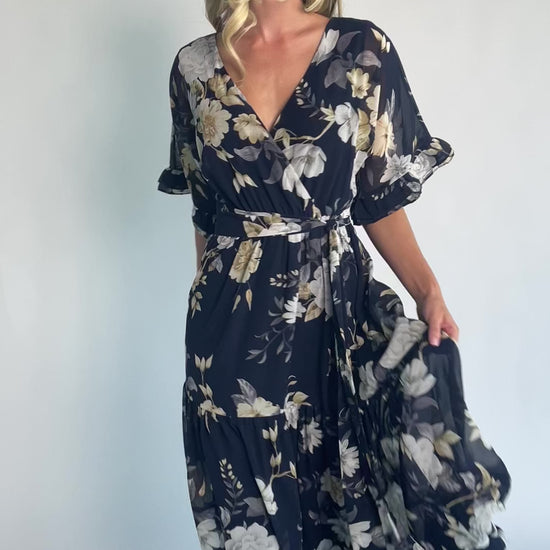 Luna Maxi Dress in Navy Floral with surplice V-neck, flutter sleeves, sash waist, and flowing tiered skirt.
