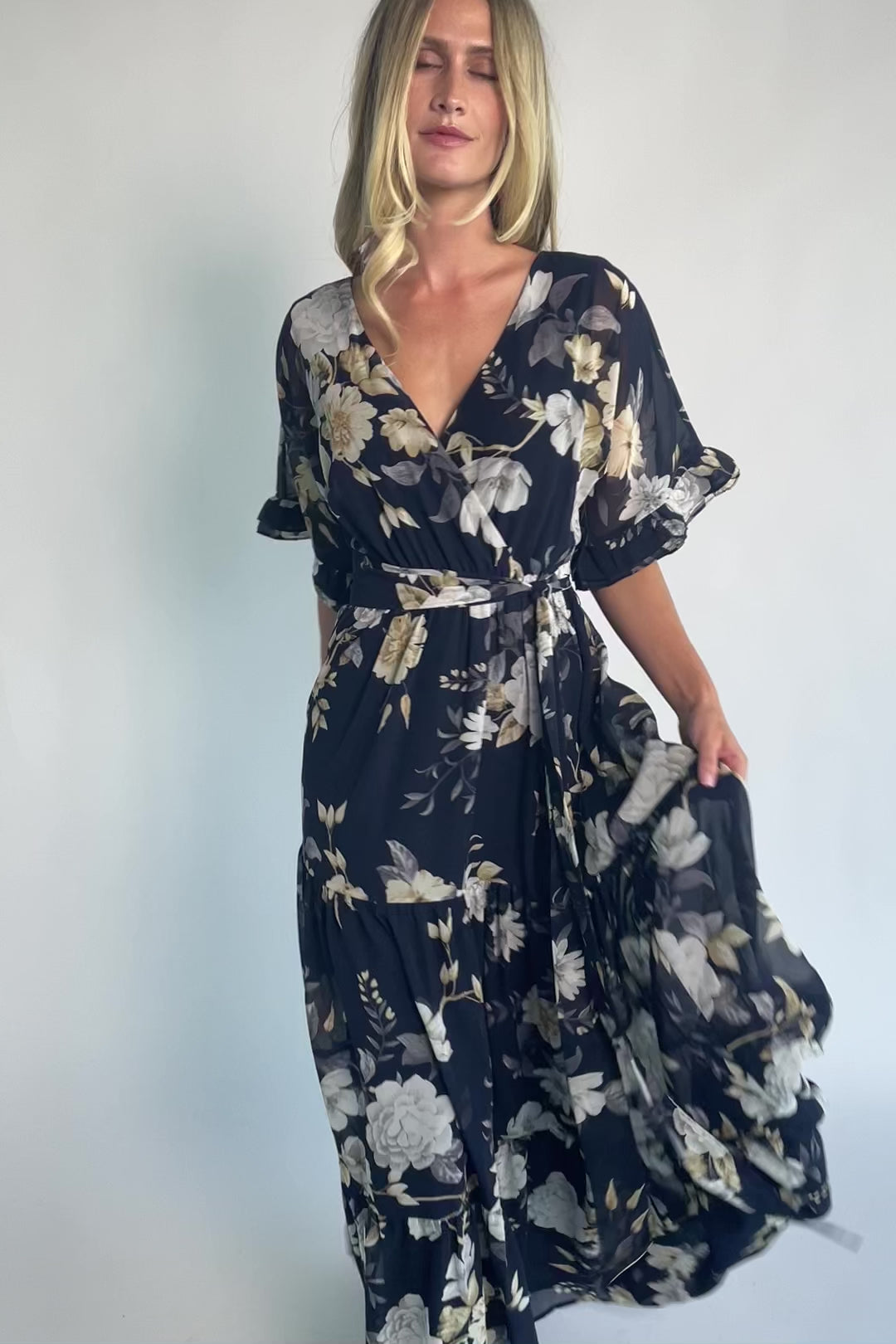 Luna Maxi Dress in Navy Floral with surplice V-neck, flutter sleeves, sash waist, and flowing tiered skirt.