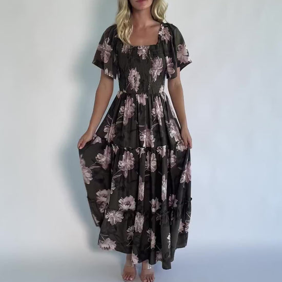 Dark olive floral maxi dress with a smocked bodice, square neckline, flutter sleeves, and a tiered ruffle skirt.