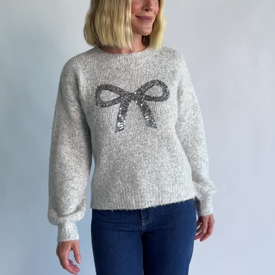 Bow Sweater in Gray with a sparkling sequin bow at the front, a crew neckline, and a heathered knit finish.