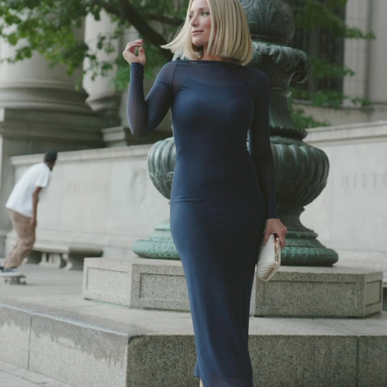 Model wearing the Darya Mesh Midi Dress in Navy featuring a sheer mesh overlay with a round neckline, long sleeves, and a fitted bodycon midi silhouette layered over a matching ribbed slip.