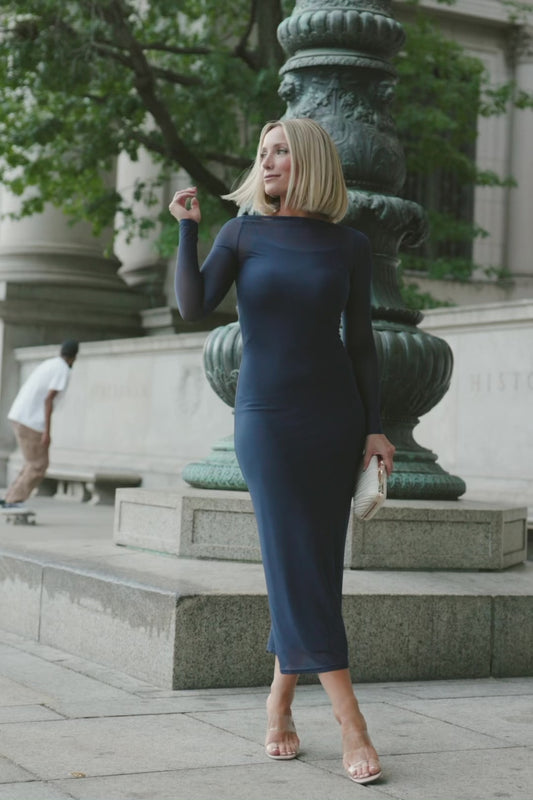 Model wearing the Darya Mesh Midi Dress in Navy featuring a sheer mesh overlay with a round neckline, long sleeves, and a fitted bodycon midi silhouette layered over a matching ribbed slip.