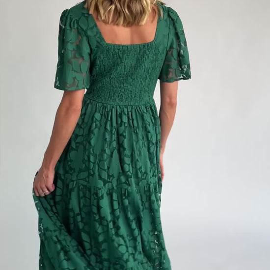 Floral lace midi dress with a deep V-neckline, short flutter sleeves, smocked back bodice, defined waistband, and tiered skirt.