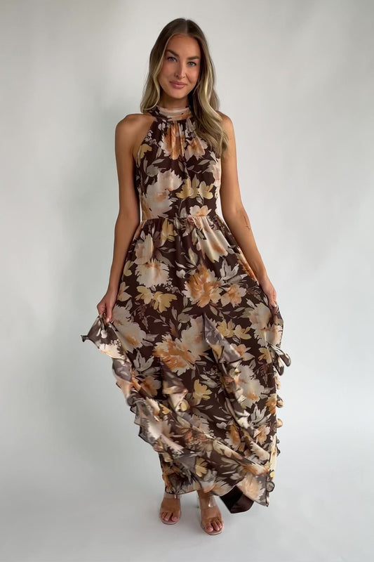 Brown and golden floral chiffon maxi dress with a high halter neckline, cascading ruffle details, smocked back waistband, and a flowing silhouette.