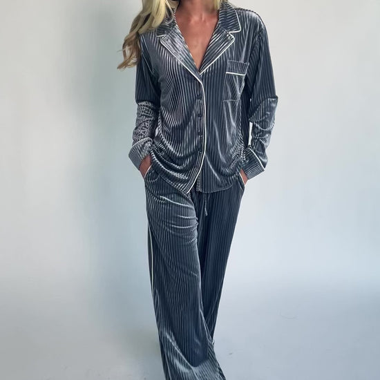 Dusty blue ribbed velvet pajama set with a collared button-front top, chest pocket, long sleeves, and wide-leg pants with an elastic drawstring waist and side pockets.