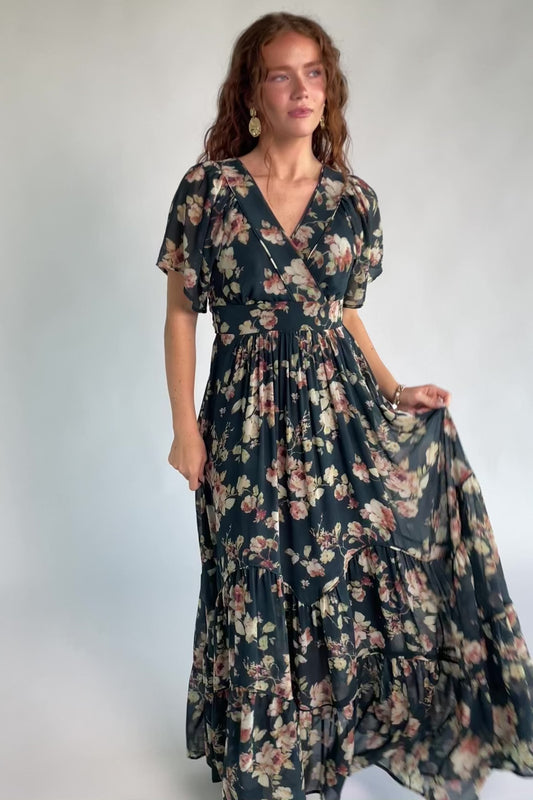 Katherine Maxi Dress in Deep Blue Floral with surplice V-neck, flutter sleeves, adjustable waist ties, and tiered skirt.