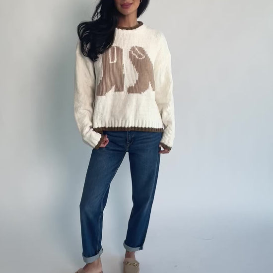 Model wearing the Wild West Knit Sweater in Cream featuring a relaxed fit, Western-inspired yoke detailing, textured knit stitching, long sleeves, and ribbed trim at the neckline, cuffs, and hem.