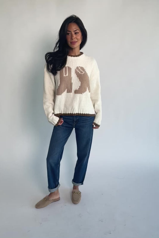 Model wearing the Wild West Knit Sweater in Cream featuring a relaxed fit, Western-inspired yoke detailing, textured knit stitching, long sleeves, and ribbed trim at the neckline, cuffs, and hem.