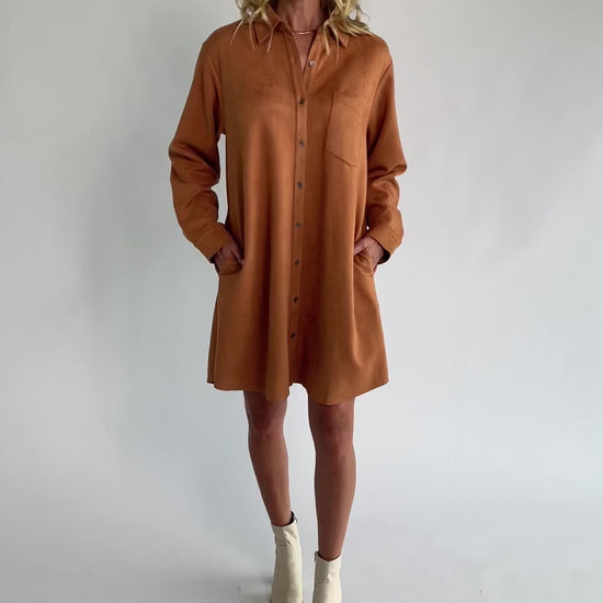 Camel faux suede shirt dress with a collared neckline, button-front closure, front patch pocket, long sleeves, and a relaxed oversized silhouette.