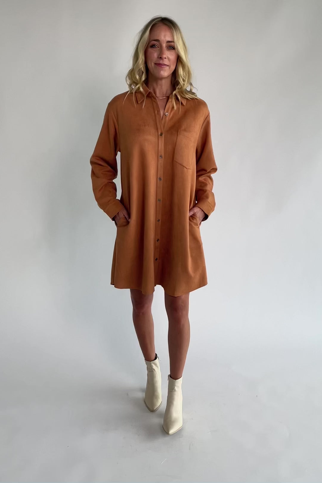 Camel faux suede shirt dress with a collared neckline, button-front closure, front patch pocket, long sleeves, and a relaxed oversized silhouette.