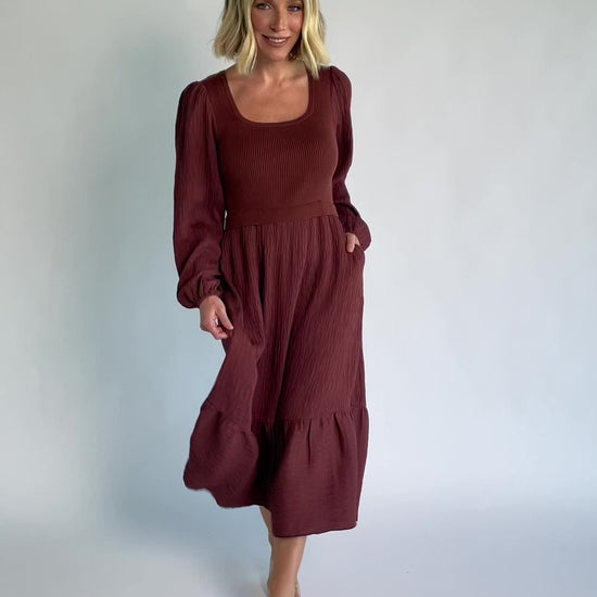 Alva Sweater Dress in Dusty Mahogany with ribbed knit bodice, square neckline, ruffle shoulders, long sleeves, and midi skirt.