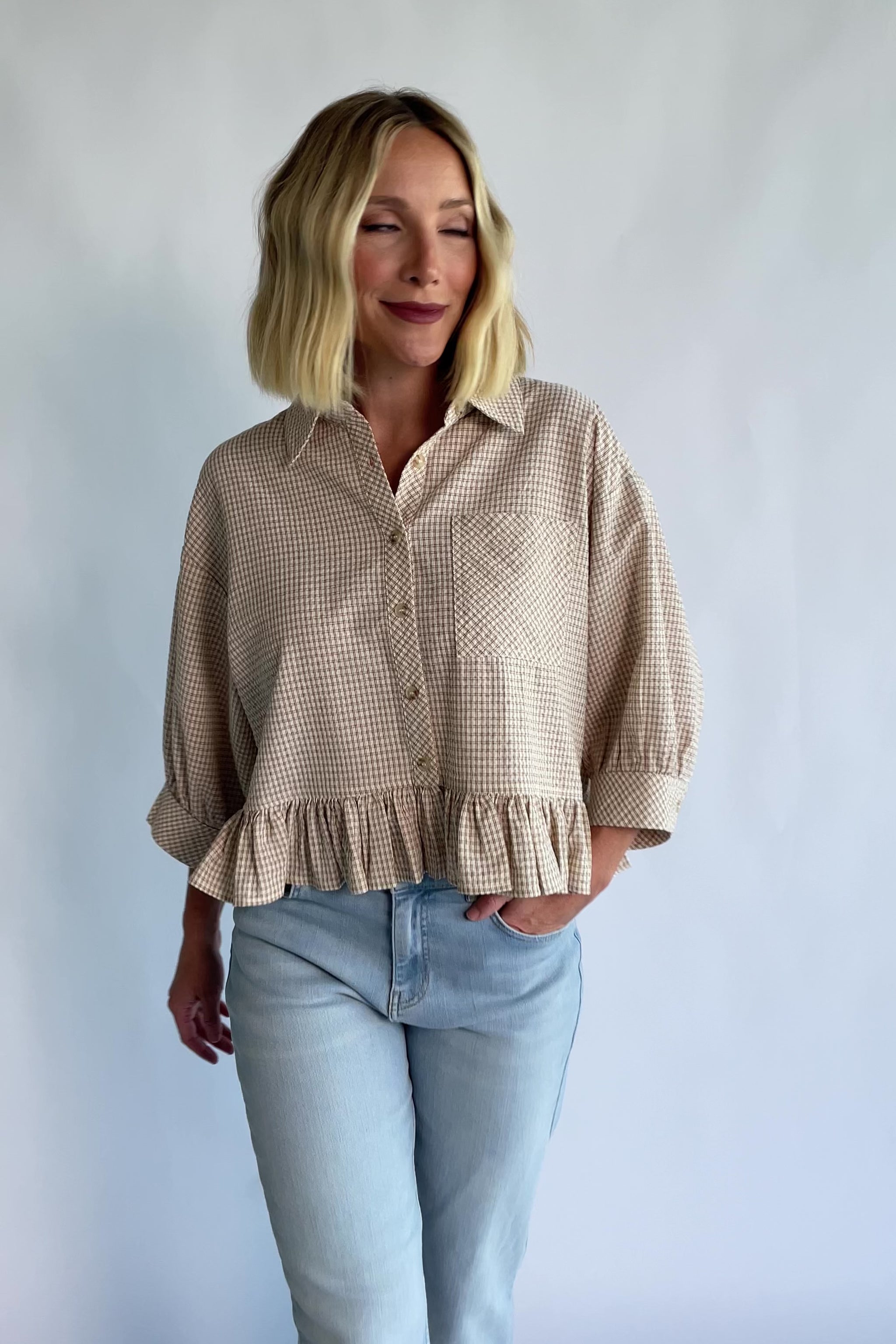 Murphy Relaxed Peplum Top in Beige with a collared neckline, button-front closure, chest pocket, and peplum hem.
