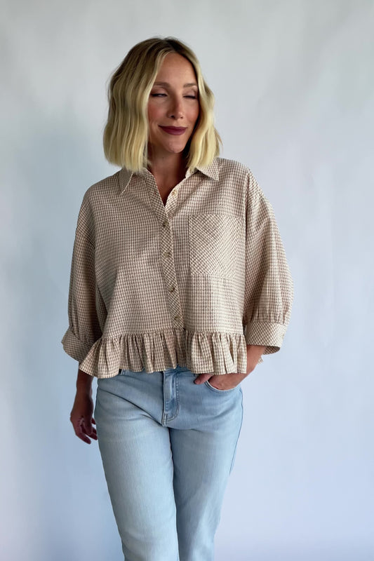 Murphy Relaxed Peplum Top in Beige with a collared neckline, button-front closure, chest pocket, and peplum hem.