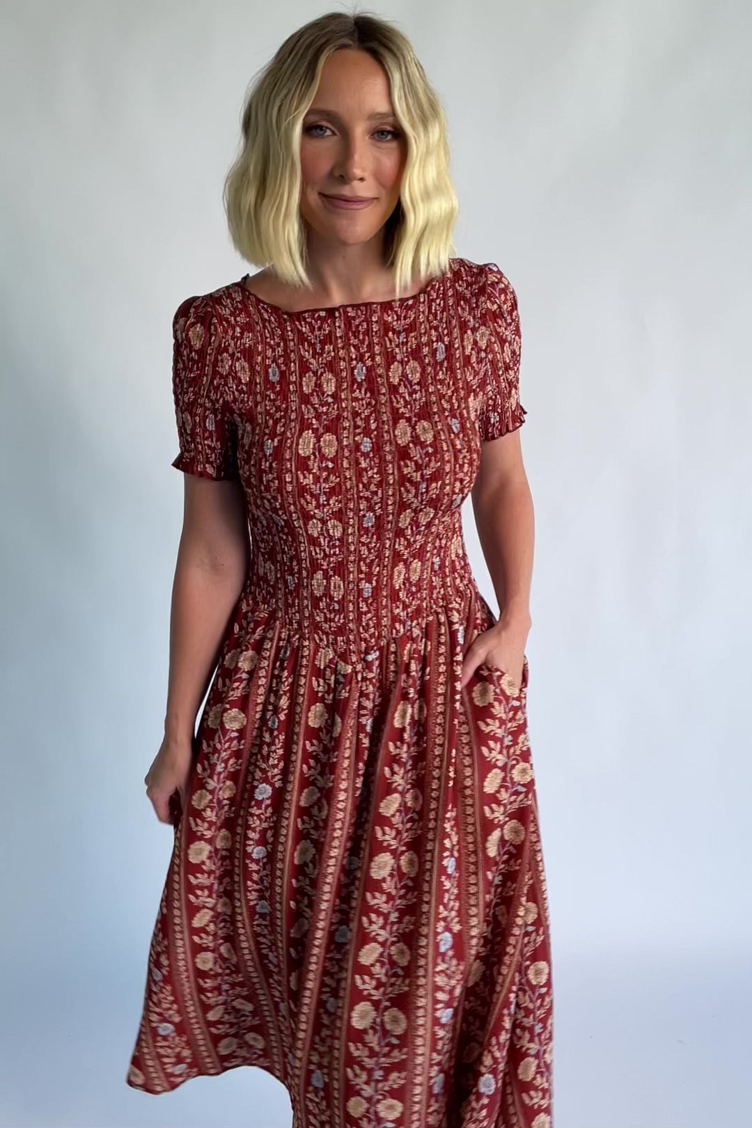 Rhonda Smocked Midi Dress in Rust Print with a round neckline, smocked bodice, and ruffled sleeve edges.