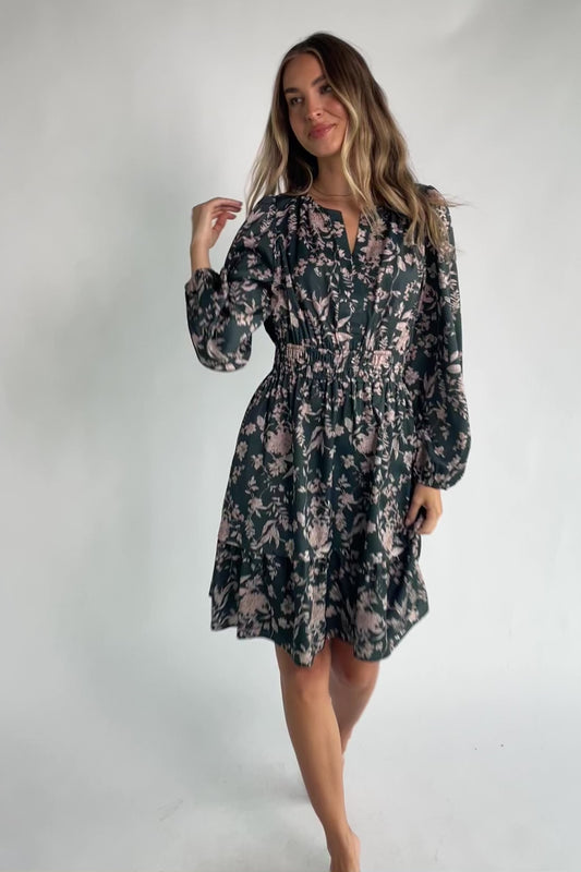 Green floral long sleeve mini dress with a notched V-neckline, elastic waist, tiered skirt, side pockets, and a lined skirt.