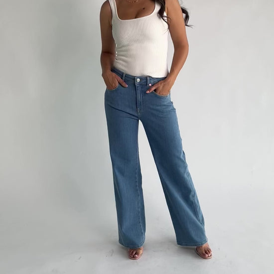 Vesper Mid Rise Wide Leg Jeans in Mid Wash with relaxed wide legs, mid-rise waist, button and zipper closure.