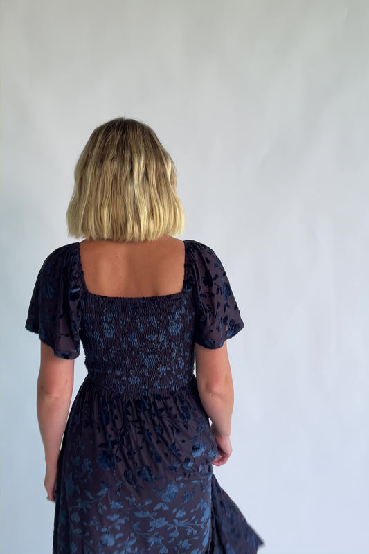 Amoret Midi Dress in Midnight Navy Floral with raised velvet florals, a sweetheart neckline, and flutter sleeves.