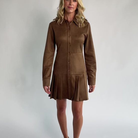 Coffee faux suede mini dress with a collared neckline, button-front closure, long sleeves, fitted waist, and pleated skirt.