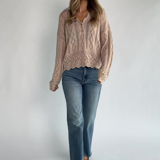 Oatmeal pointelle knit sweater with a scalloped henley neckline, functional button front, dropped shoulders, long sleeves, and a scalloped hem.