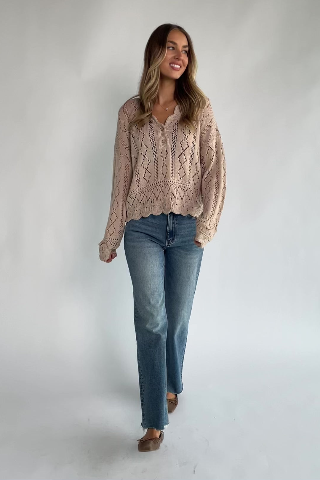 Oatmeal pointelle knit sweater with a scalloped henley neckline, functional button front, dropped shoulders, long sleeves, and a scalloped hem.