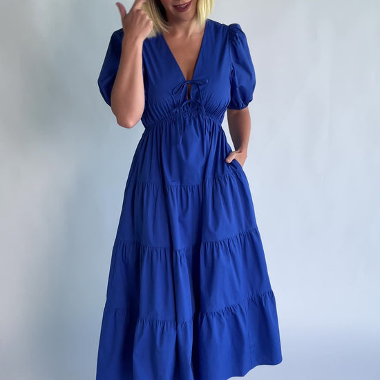 Sheila Tiered Midi Dress in Cobalt with V-neckline, front ties, puff sleeves, smocked empire waist, and tiered skirt.