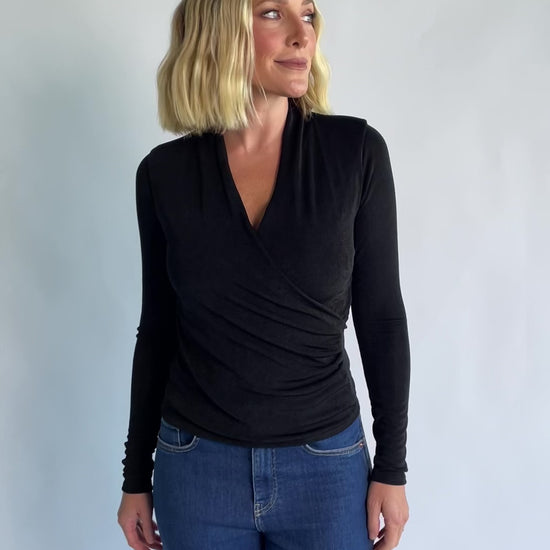 Aelia Top in Black with a plunging V-neckline, crossover front, and ruching along the side.