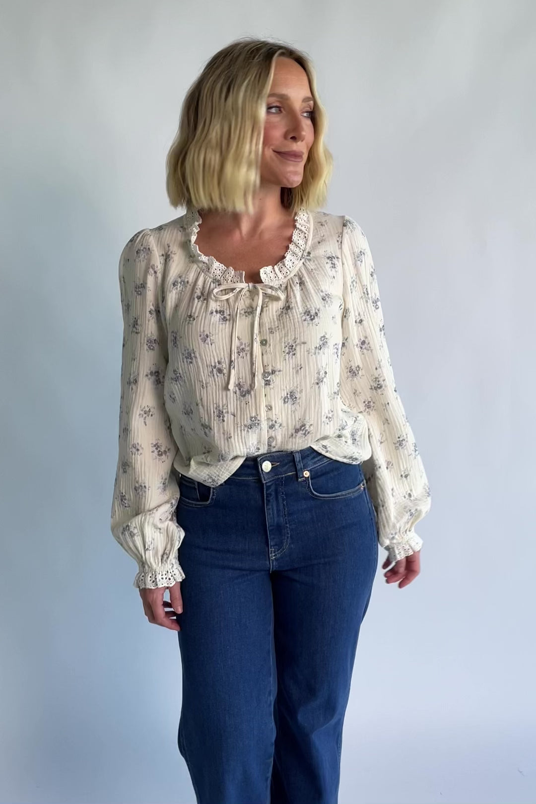 Stephanie Button Front Blouse in Ivory + Blue Floral with a lace-trimmed tie neckline and a button-front design.