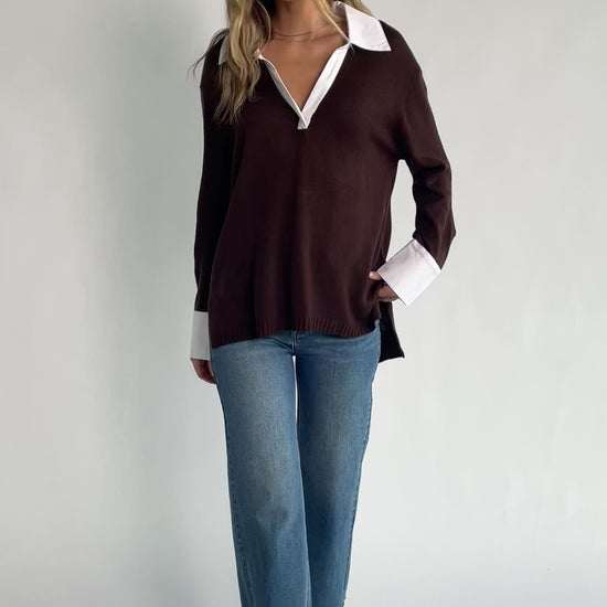 Chocolate sweater top with a contrast white collared neckline and cuffs, split V-neck, long sleeves, side hem slits, ribbed hem, and a relaxed fit.