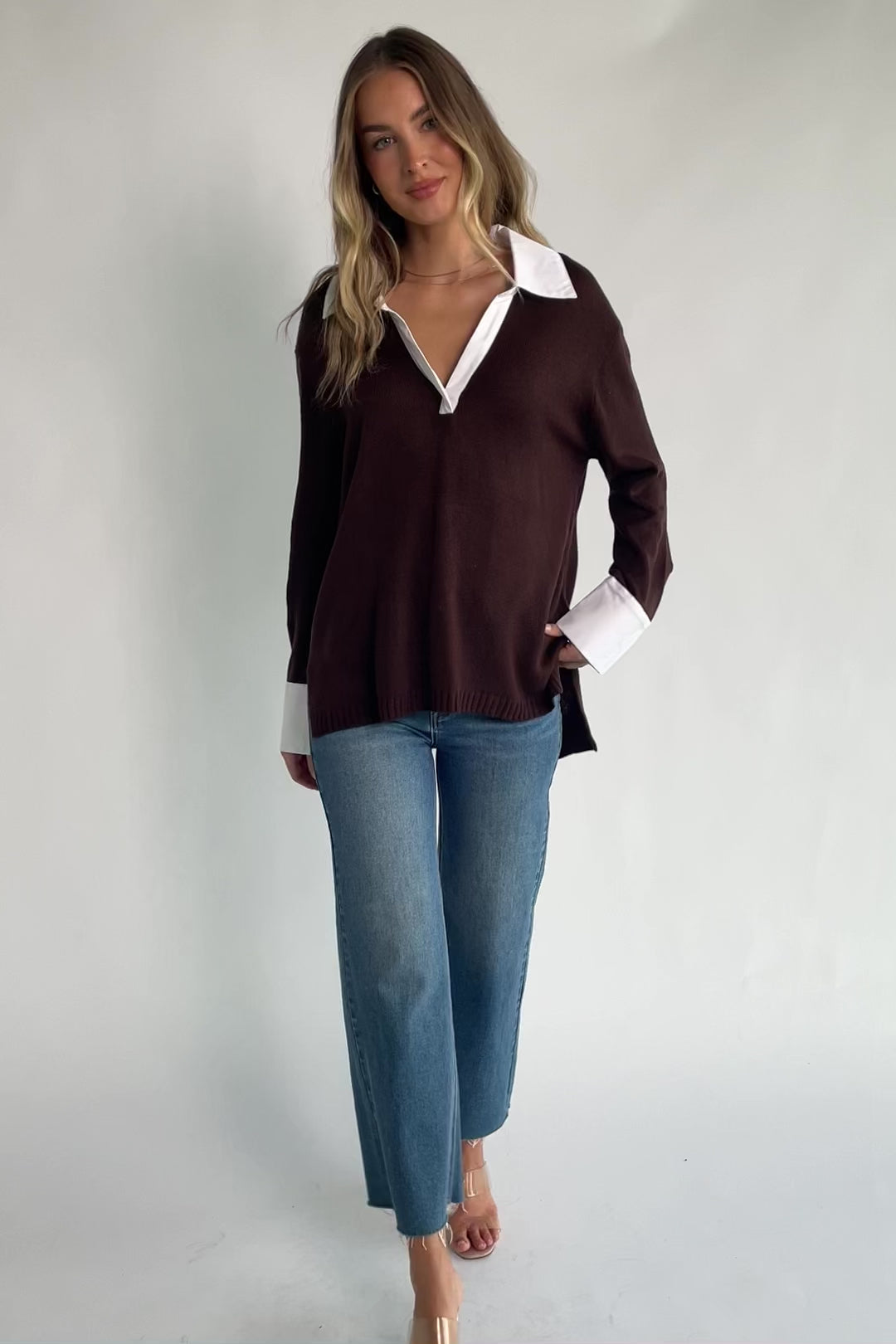 Chocolate sweater top with a contrast white collared neckline and cuffs, split V-neck, long sleeves, side hem slits, ribbed hem, and a relaxed fit.