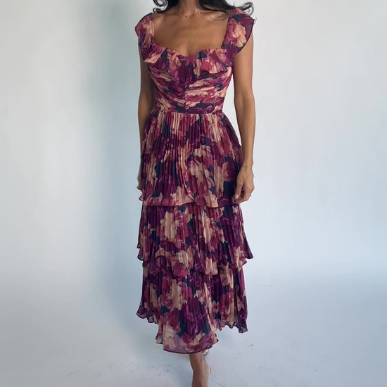 Model wearing the Steinway Pleated Midi Dress in Berry Floral featuring a pink, berry, and mauve floral print on lightweight pleated chiffon.