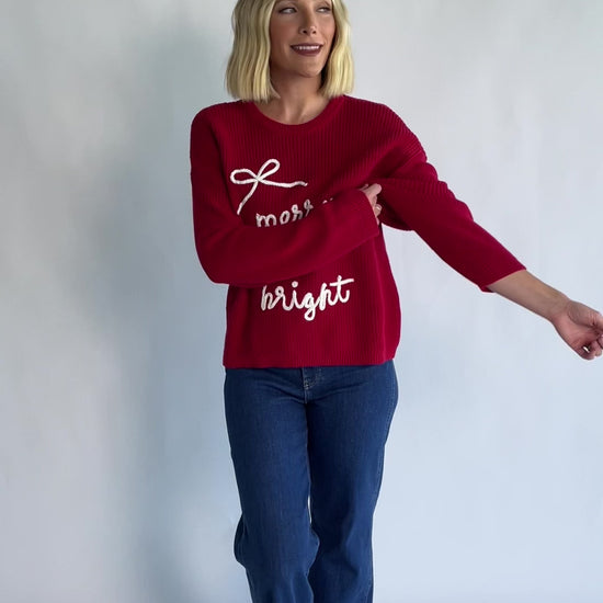 Merry Sweater in Red + Off White with a crew neckline, soft knit fabric, and embroidered Merry & Bright graphic.