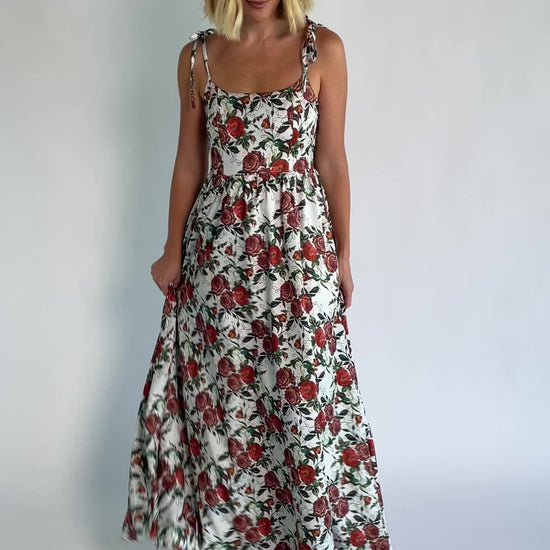 Nadine Maxi Dress in Red + Green Floral with tie straps, smocked back, flowing skirt, and left leg slit.