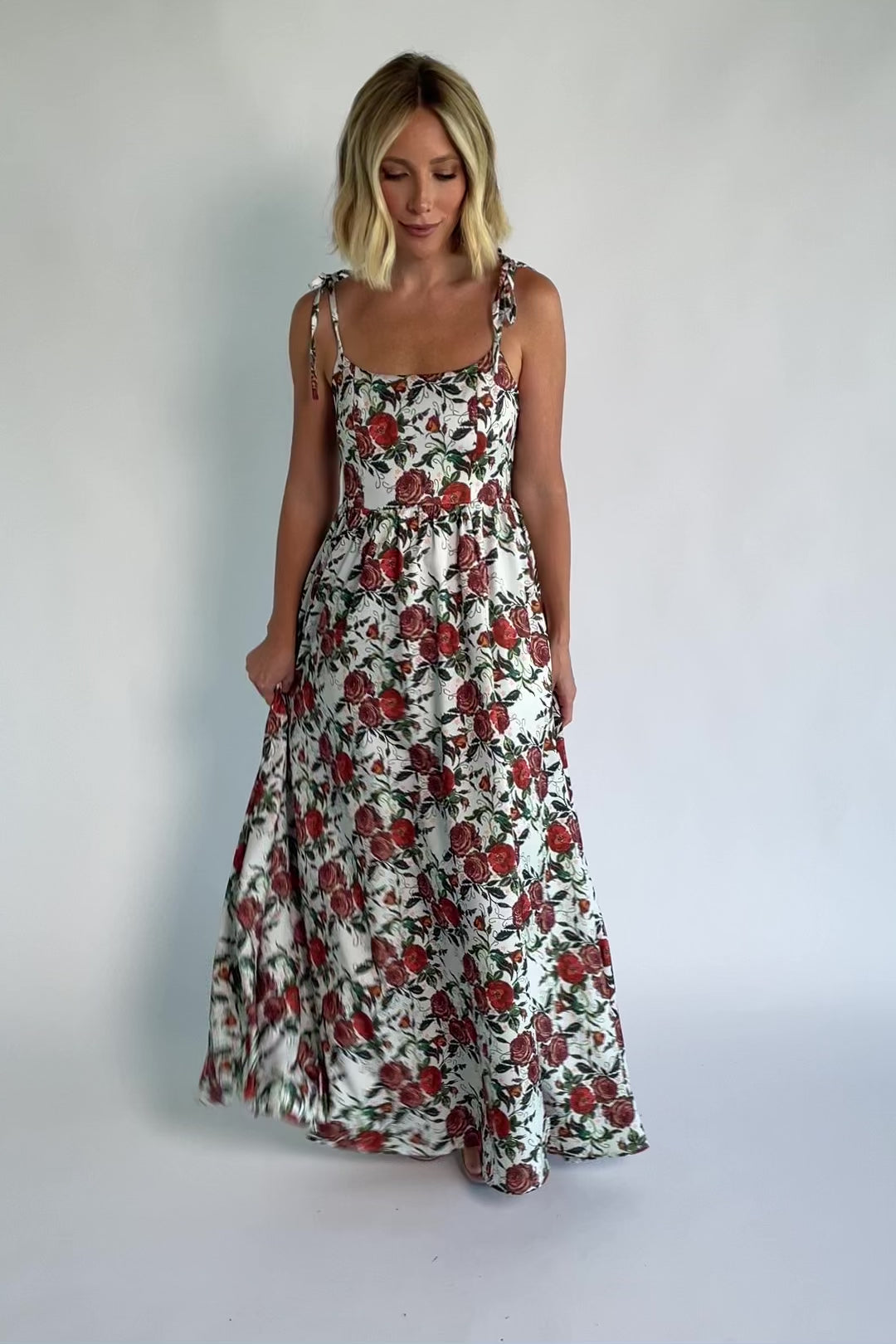 Nadine Maxi Dress in Red + Green Floral with tie straps, smocked back, flowing skirt, and left leg slit.
