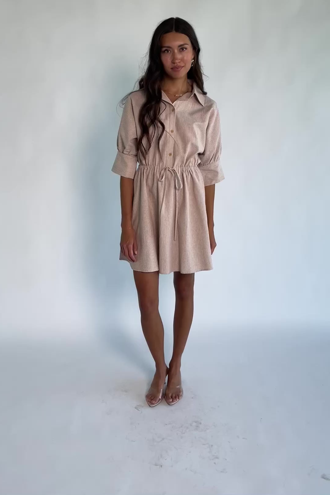 Model wearing the Beekman Short Dress in Natural Stripe featuring a collared neckline, functional button-front closure, elbow-length sleeves with wide cuffs, and a removable waist tie.