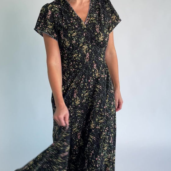 Jada Maxi Dress in Black Floral with V-neckline, blue scalloped trim, flutter sleeves, empire waist, and tie waist.
