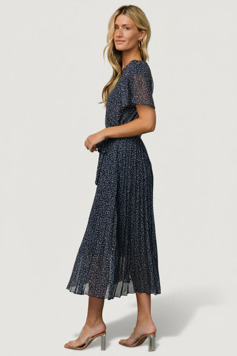 Detail shot of the removable waist tie and elastic gathering on the Prim Pleated Midi Dress, illustrating fit and tailoring options.