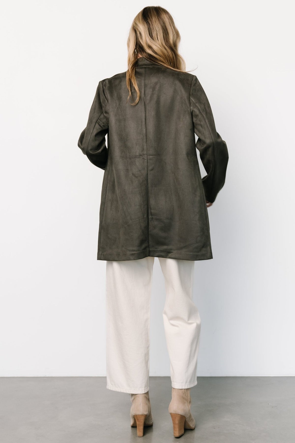 Back view of thigh-length charcoal jacket showing center seam, smooth lining edge, and relaxed silhouette.
