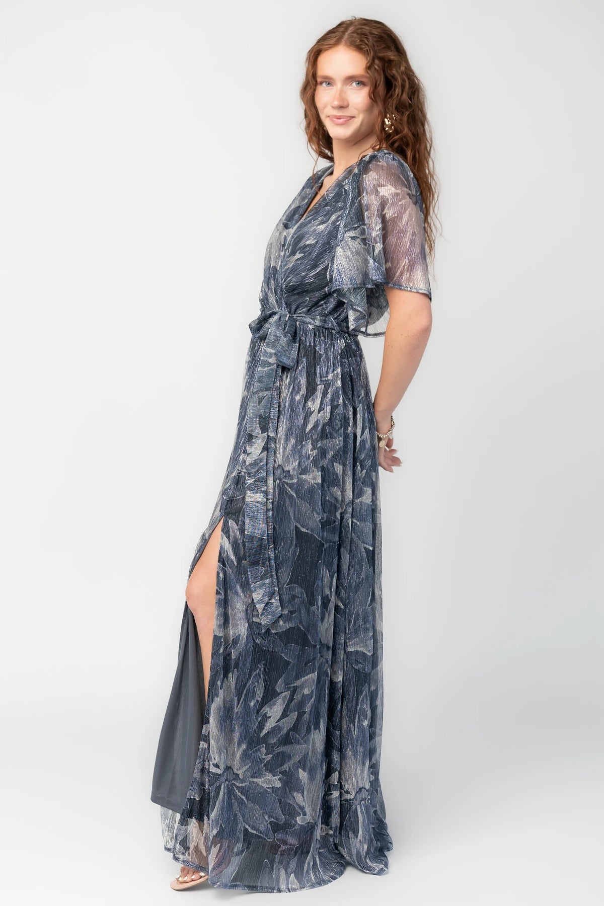 Rachel Maxi Dress in Blue Multi with silver shimmer leaves, surplice neckline, sash waist, and leg slit.