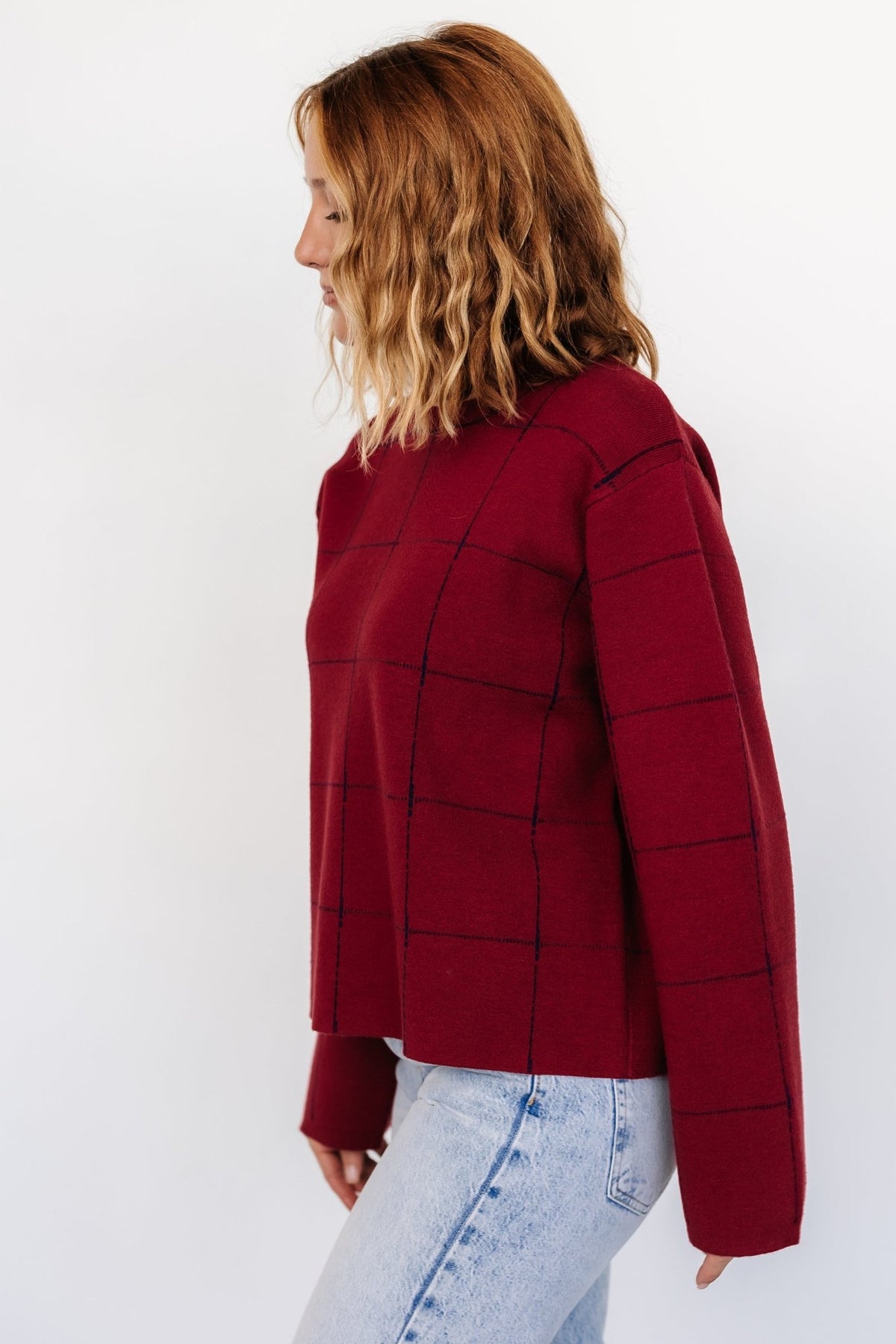 Detail shot of the round neckline and shoulder seam on the Remington Sweater, with visible navy windowpane contrast and neat finishing at the collar.