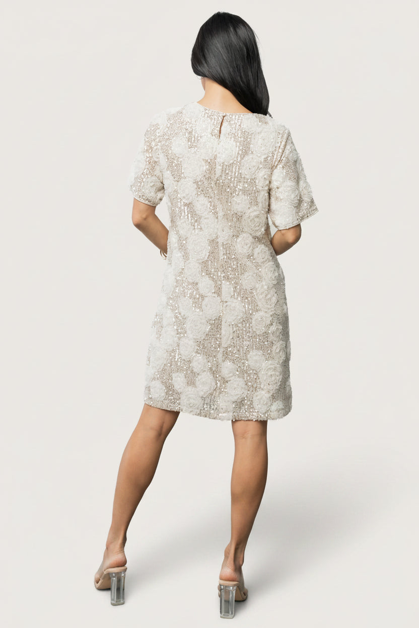 Rhea Sequin Short Dress in Ivory with silver sequins, floral mesh appliqués, round neckline, short sleeves, and shift silhouette.