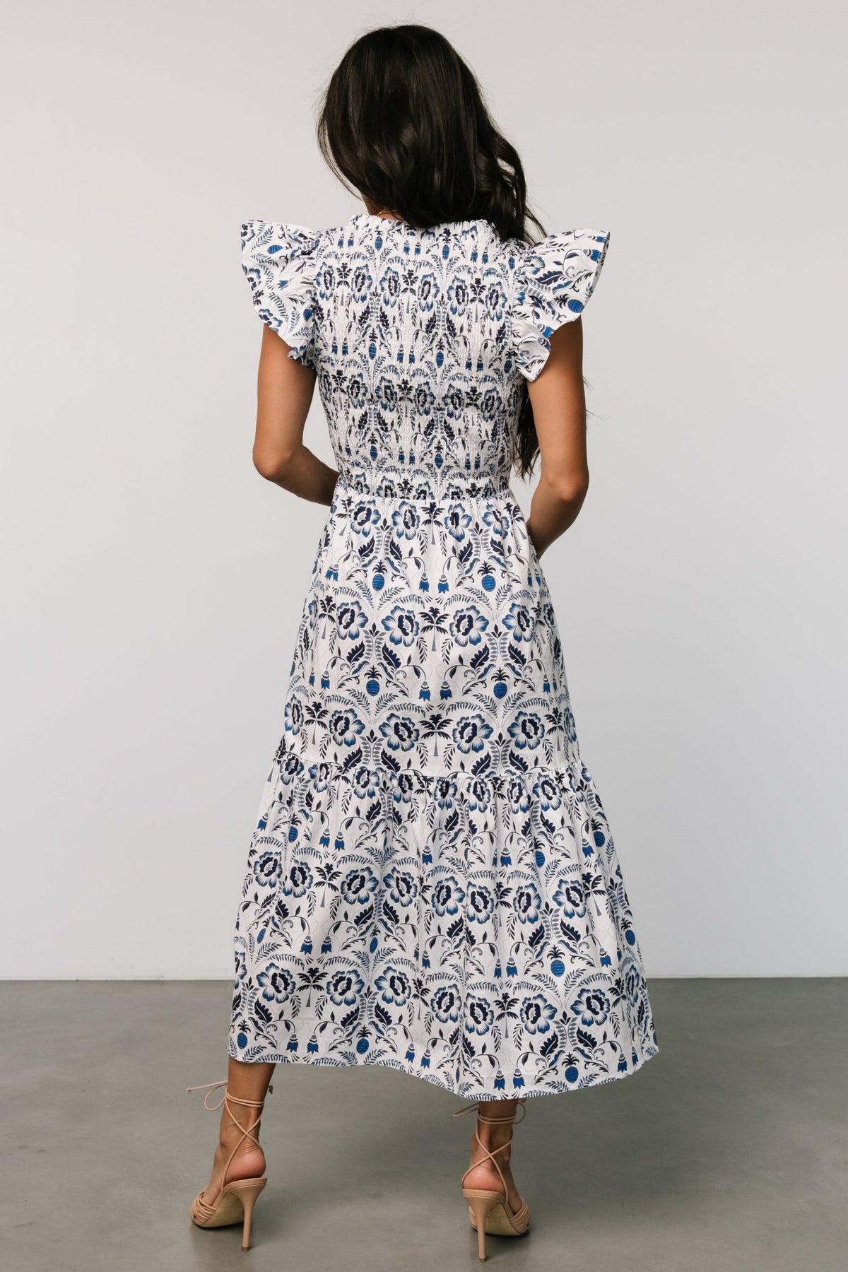 Side view showing single-tiered midi skirt and practical side pocket on a lightweight, unlined 100% cotton floral dress.
