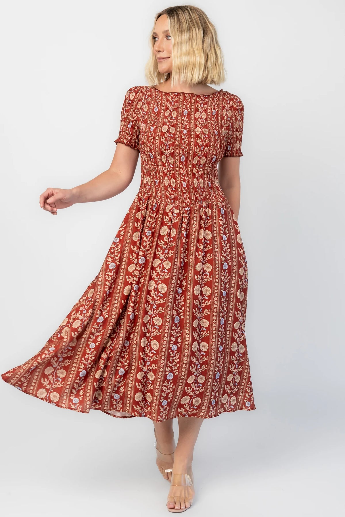 Rhonda Smocked Midi Dress in Rust Print with a round neckline, smocked bodice, and ruffled sleeve edges.
