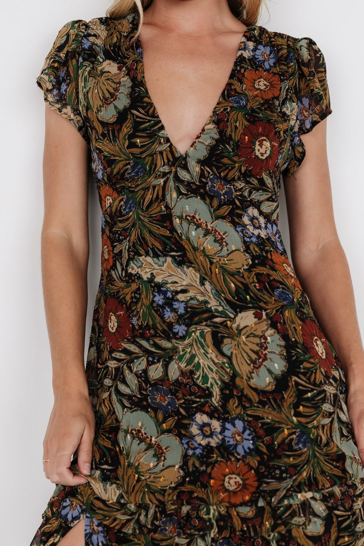 Side view highlighting the right-side leg slit, layered ruffle tiers, and flowing chiffon fabric with subtle shimmer.