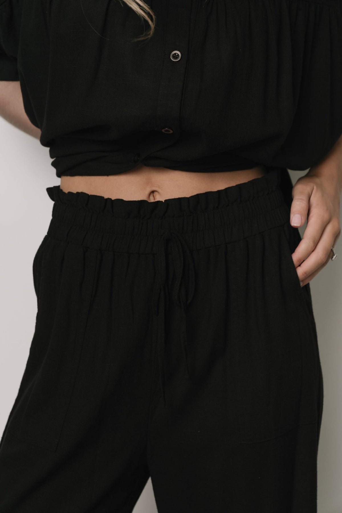 Close-up of Romy pants waist showing smocked elastic detail, faux tie, and subtle linen-blend weave for comfortable, polished wear.