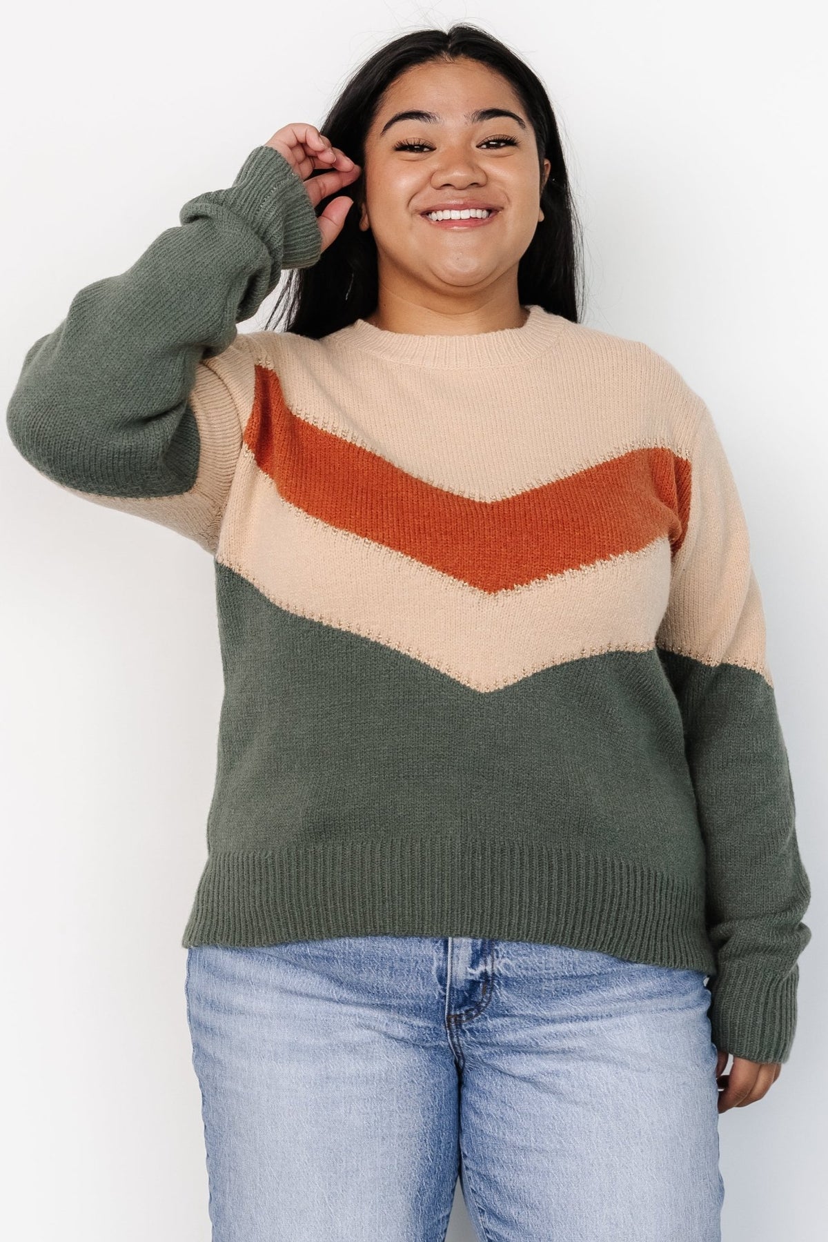 Model wearing Rowen sweater in natural and green chevron pattern, showing relaxed pullover fit and mid-length hem styling.